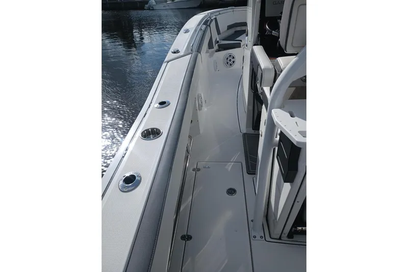 Slide: The Image of 2020 Blackfin 272 CC boat deck with rod holders and seating, docked by water. - 21