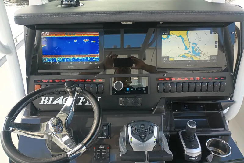Slide: The Image of 2020 Blackfin 272 CC boat dashboard with Garmin displays and steering wheel. - 24