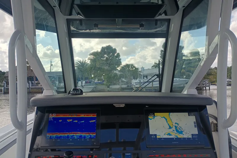 Slide: The Image of Interior view of 2020 Blackfin 272 CC boat with navigation screens and waterfront scenery. - 25