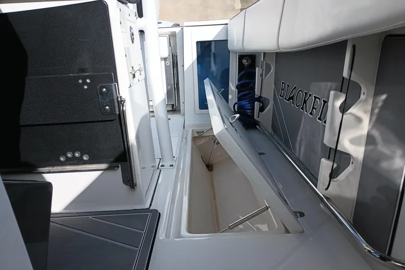 Slide: The Image of 2020 Blackfin 272 CC boat interior with open storage compartment and seating area. - 38