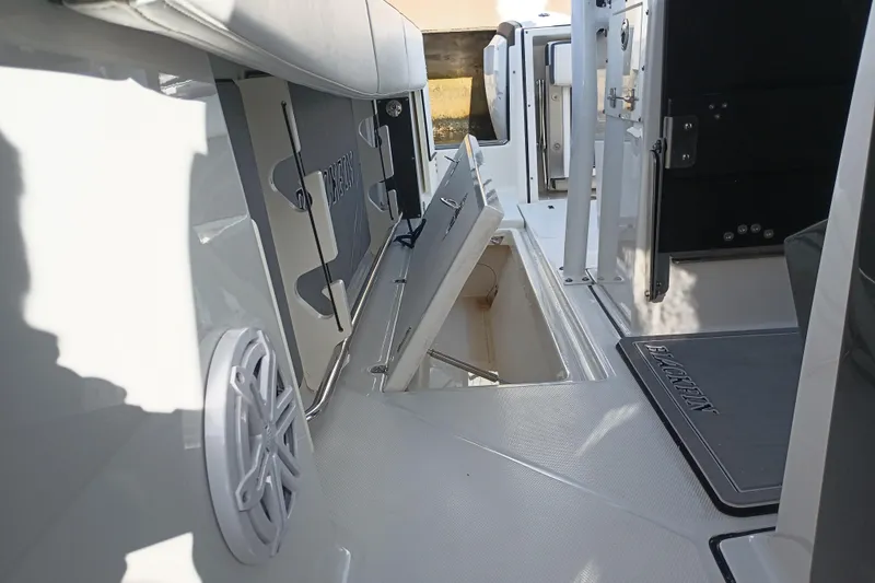 Slide: The Image of 2020 Blackfin 272 CC boat interior with open storage compartment and speaker. - 40