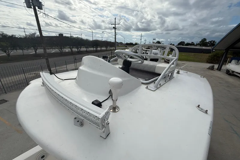 Slide: The Image of 2021 Sea Cat 260 boat with steering wheel and light bar, parked outdoors under cloudy sky. - 11