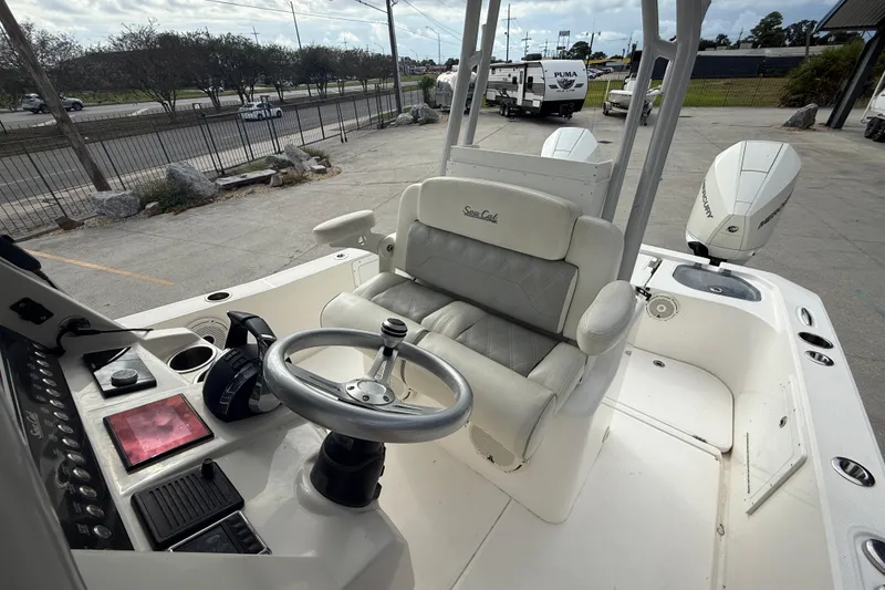 Slide: The Image of 2021 Sea Cat 260 boat interior with steering wheel and dual Mercury engines. - 12