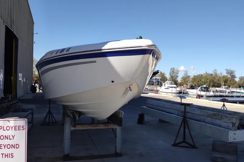 Slide: The Image of 2004 Baja H2X boat on dry dock near marina, clear sky background. - 18