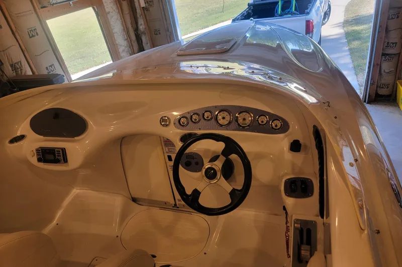 Slide: The Image of 2004 Baja H2X boat interior with steering wheel and dashboard in a garage setting. - 21