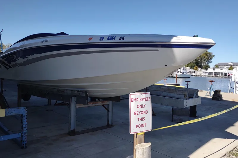 Slide: The Image of 2004 Baja H2X boat on dock with "Employees Only" sign, near waterfront. - 7