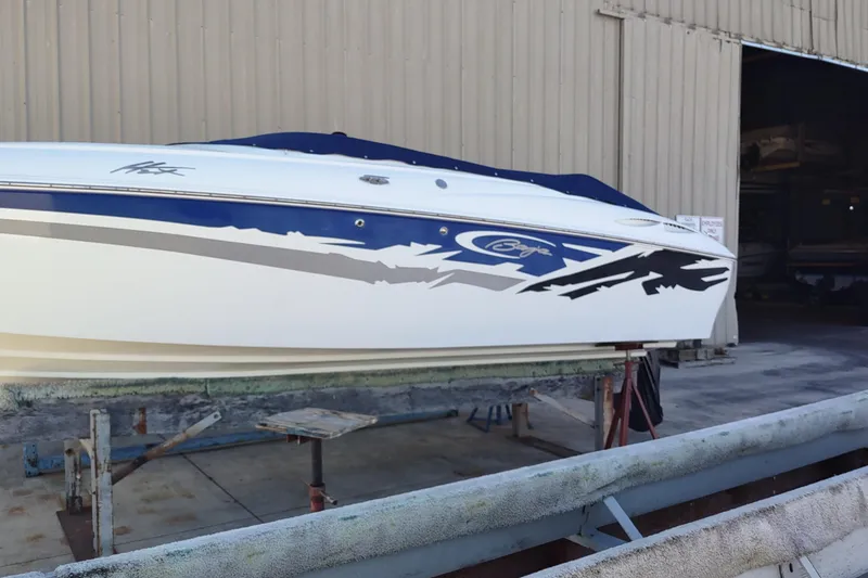Slide: The Image of 2004 Baja H2X boat with blue and white design in a storage facility. - 9