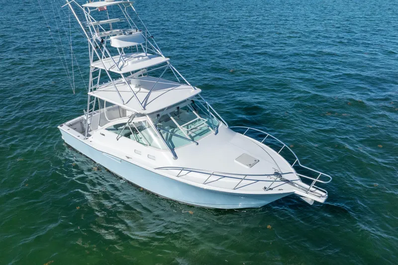 The Image of 2004 Cabo 35 Express boat on calm blue water, featuring a sleek design and spacious deck. - 0