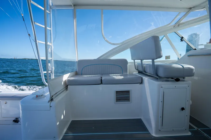 Slide: The Image of 2004 Cabo 35 Express boat interior with seating, ocean view, and clear blue sky. - 12