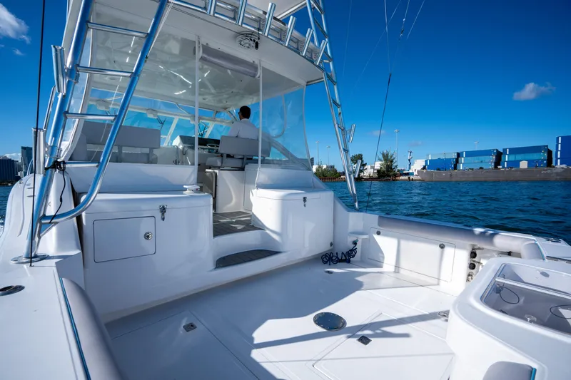 Slide: The Image of 2004 Cabo 35 Express boat on water, clear sky, modern design, spacious deck. - 22