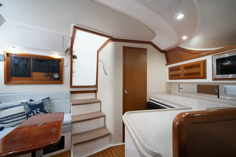 Slide: The Image of 2004 Cabo 35 Express interior with stairs, seating, and kitchen area. - 28
