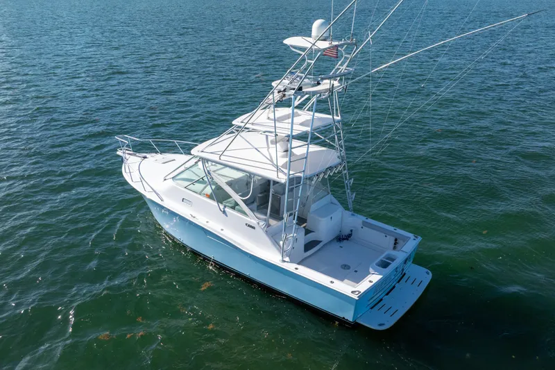 Slide: The Image of 2004 Cabo 35 Express boat on open water, featuring a sleek design and fishing equipment. - 3