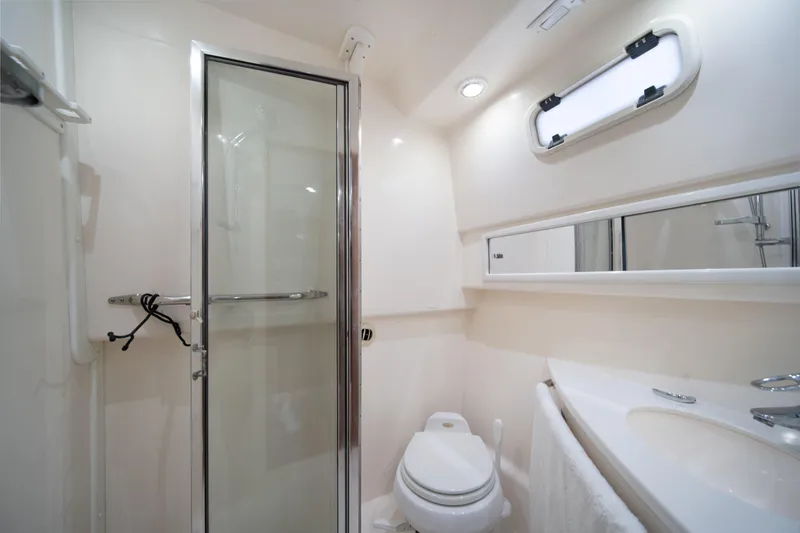 Slide: The Image of Luxurious bathroom in 2004 Cabo 35 Express yacht with shower, toilet, and sink. - 32