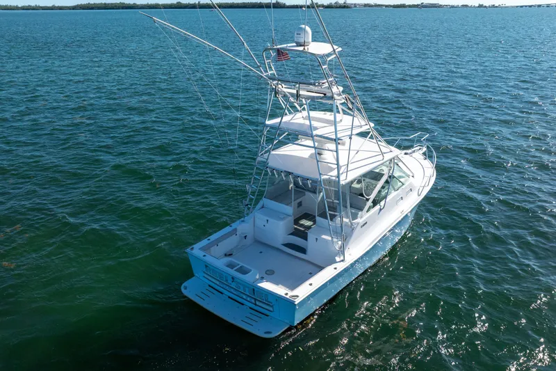 Slide: The Image of 2004 Cabo 35 Express boat on open water, showcasing sleek design and fishing tower. - 4