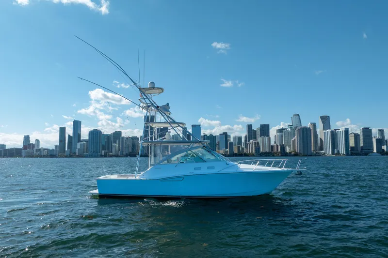 Slide: The Image of 2004 Cabo 35 Express boat on water with city skyline in background. - 6