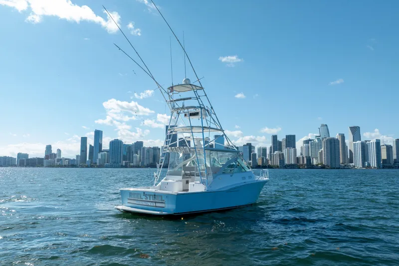 Slide: The Image of 2004 Cabo 35 Express boat on water with city skyline in background. - 7