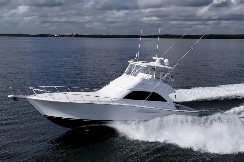 The Image of 2004 Viking 48 Convertible yacht cruising on open water under cloudy skies. - 0