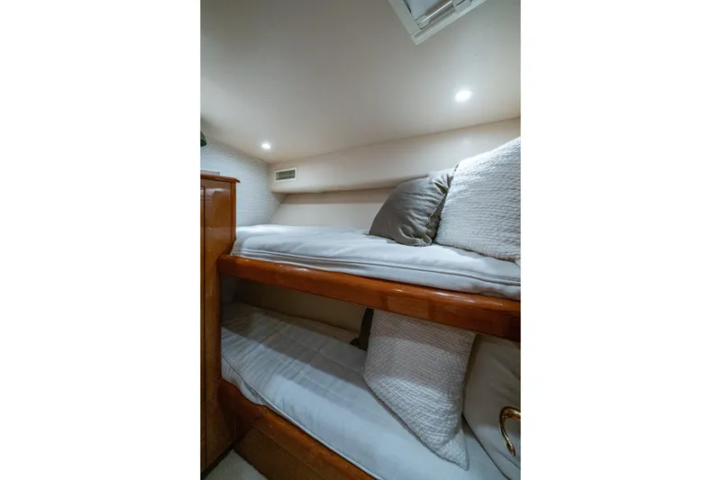 Slide: The Image of 2004 Viking 48 Convertible yacht interior with cozy bunk beds and soft lighting. - 22