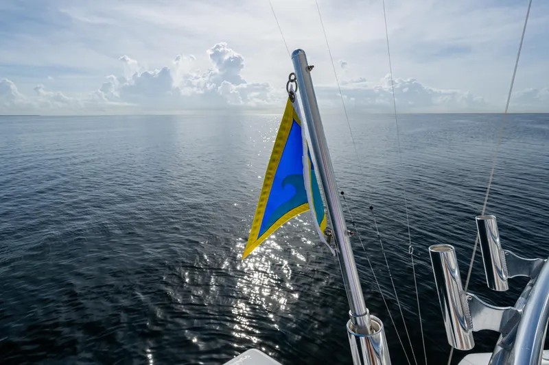 Slide: The Image of 2004 Viking 48 Convertible yacht with flag on calm ocean waters. - 38
