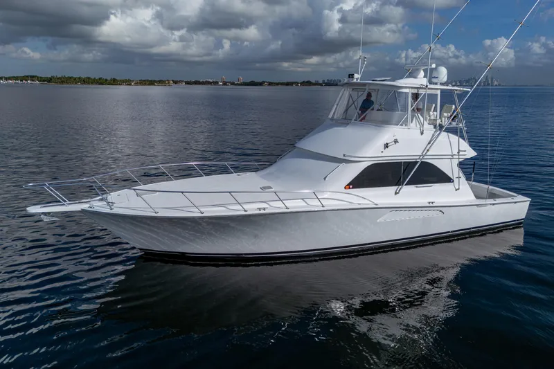 Slide: The Image of 2004 Viking 48 Convertible yacht on calm waters under cloudy sky. - 39