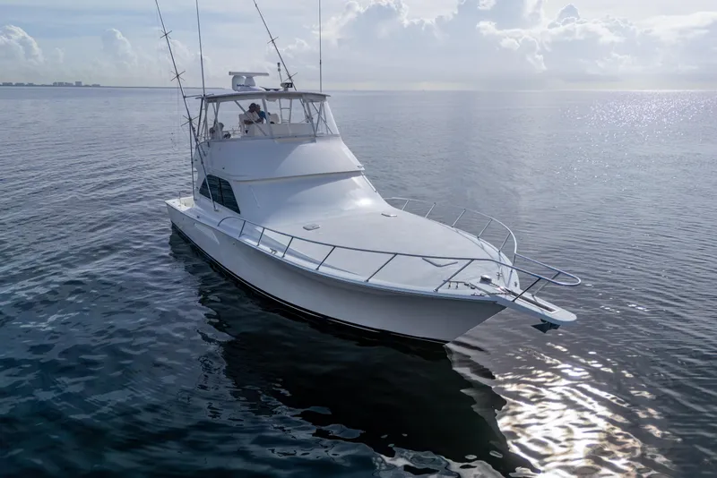 Slide: The Image of 2004 Viking 48 Convertible yacht on calm ocean waters under a cloudy sky. - 41
