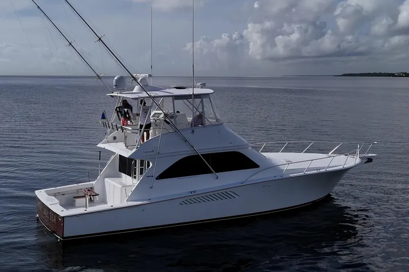 Slide: The Image of 2004 Viking 48 Convertible yacht on calm ocean waters under cloudy sky. - 49