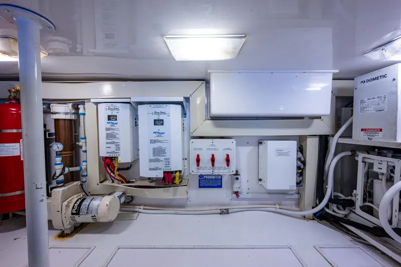Slide: The Image of Engine room of 2004 Viking 48 Convertible yacht, featuring electrical panels and equipment. - 57