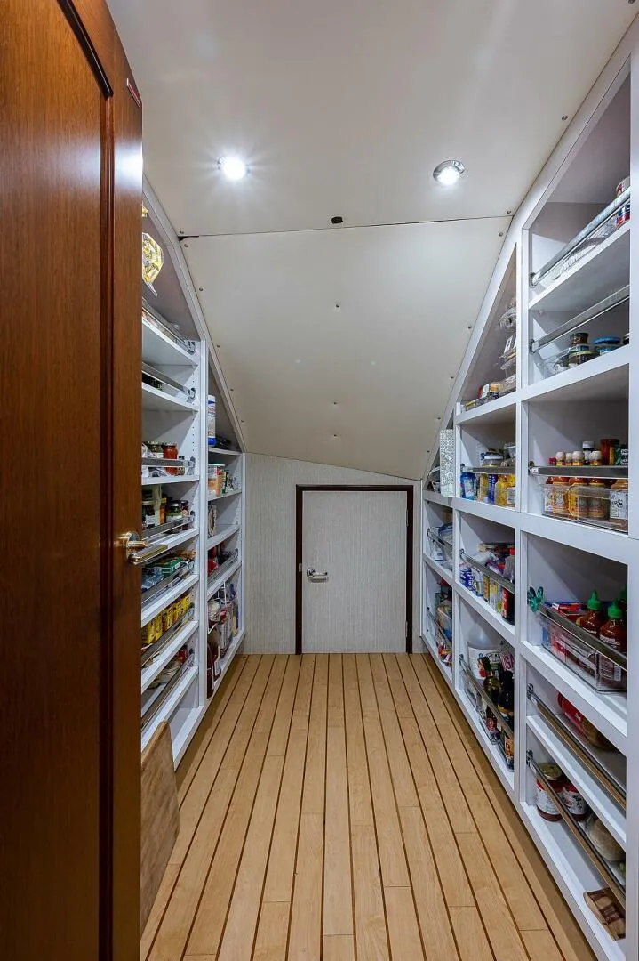 Slide: The Image of Spacious pantry with wooden flooring and well-organized shelves on a Christensen 141 Raised Pilothouse yacht. - 29