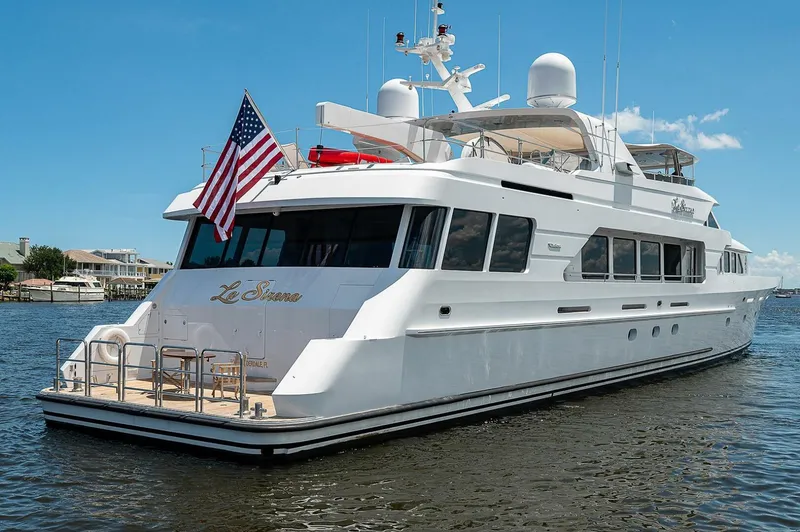Slide: The Image of Luxury Christensen 141 Raised Pilothouse yacht, 2000 model, with American flag, docked on calm water. - 8