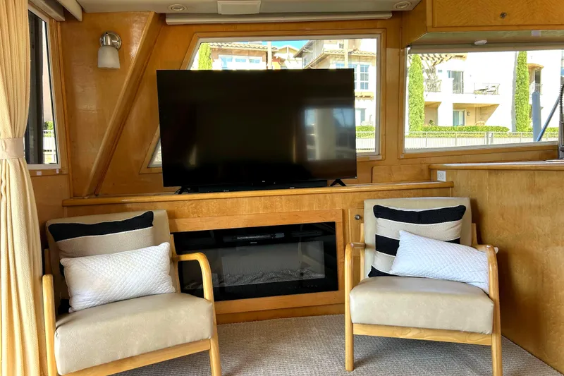 Slide: The Image of Interior of 1999 Navigator 53 Classic yacht with TV, chairs, and cushions. - 12