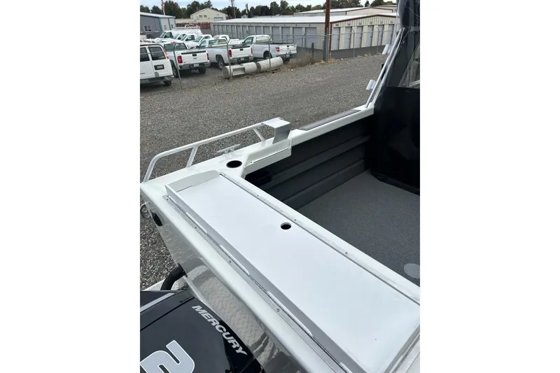 Slide: The Image of 2026 Thunder Jet 22 Chinook OS boat deck with storage and railing, parked outdoors. - 14