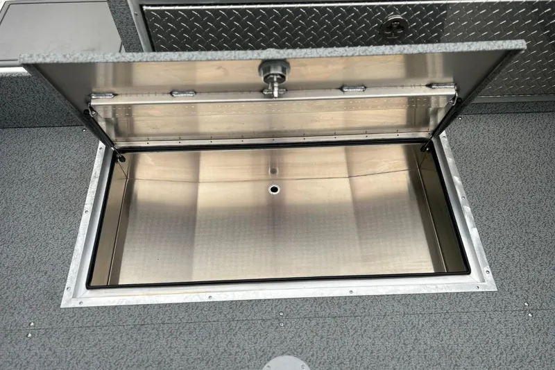 Slide: The Image of Open storage compartment on 2026 Thunder Jet 22 Chinook OS boat, featuring metal interior. - 24