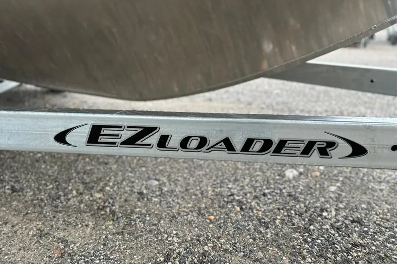 Slide: The Image of EZ Loader trailer for 2026 Thunder Jet 22 Chinook OS boat on gravel surface. - 49