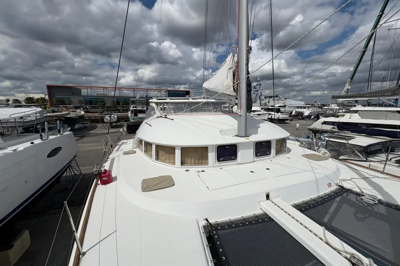 Slide: The Image of 2004 Lagoon 380 catamaran docked at a marina under cloudy skies. - 10