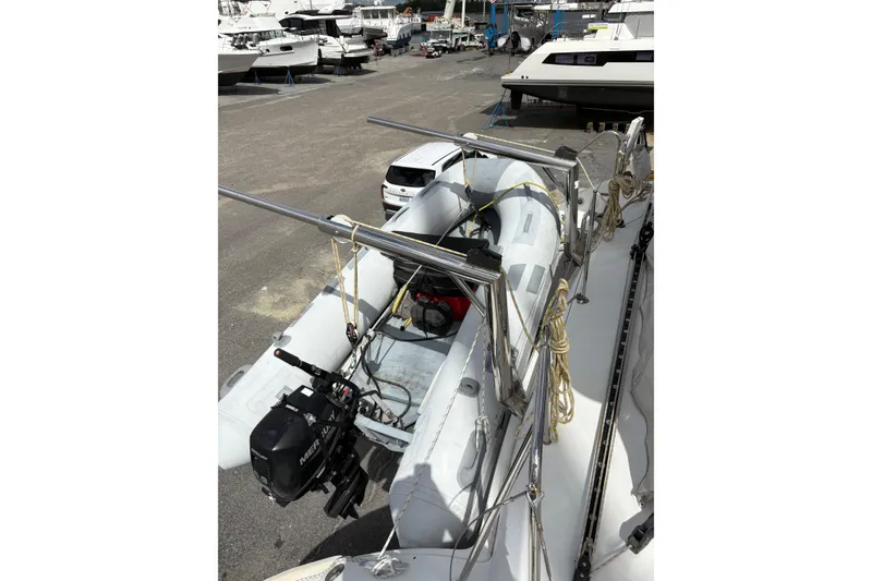 Slide: The Image of Inflatable boat with outboard motor on Lagoon 380 catamaran, 2004 model, in a marina. - 15