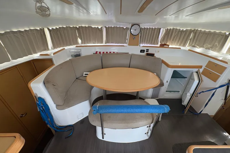 Slide: The Image of Interior of 2004 Lagoon 380 catamaran with cozy seating and round table. - 18