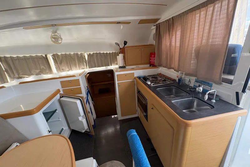 Slide: The Image of Interior of 2004 Lagoon 380 catamaran kitchen with dual sinks and stove. - 19