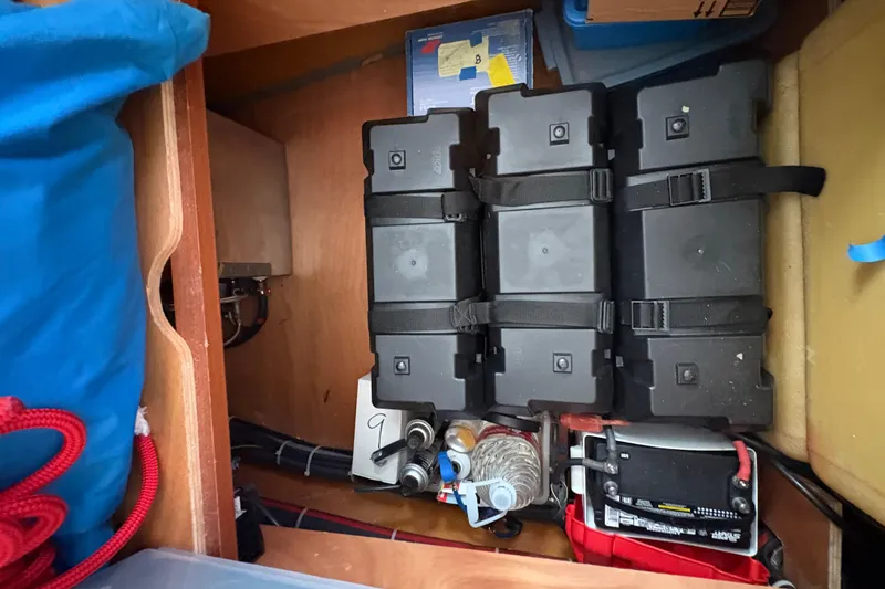 Slide: The Image of Storage compartment in a 2004 Lagoon 380 boat with batteries and equipment. - 26