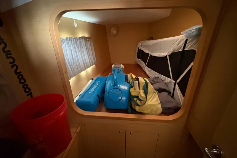 Slide: The Image of Interior cabin of 2004 Lagoon 380 catamaran with luggage and equipment. - 28