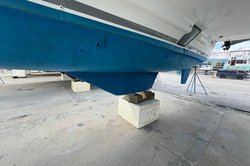 Slide: The Image of 2004 Lagoon 380 catamaran hull on dry dock, showcasing blue underside and support blocks. - 5