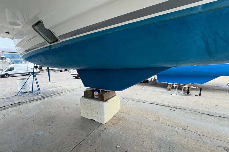 Slide: The Image of 2004 Lagoon 380 catamaran hull on dry dock, supported by blocks, in a shipyard. - 6