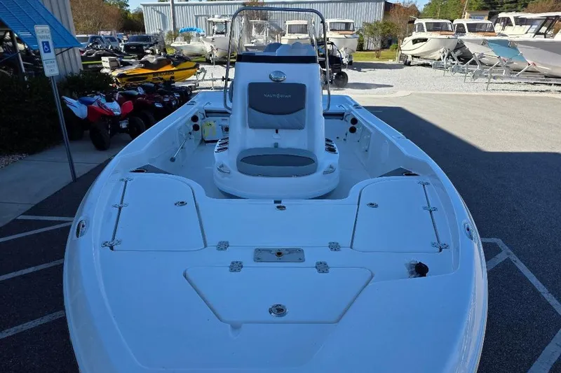 Slide: The Image of 2026 NauticStar 194 Bay boat displayed outdoors, surrounded by other vehicles. - 5