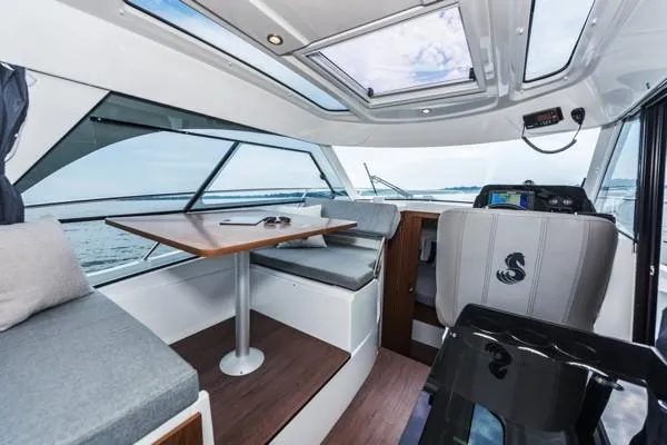 Slide: The Image of 2024 Beneteau Antares 9 interior with seating, table, and navigation area. - 7