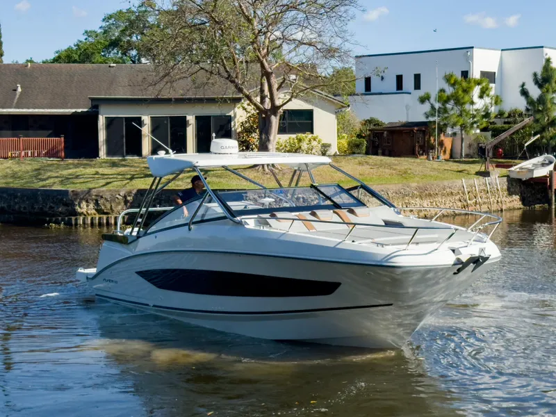 The Image of 2024 Beneteau Flyer 10 cruising on a calm river near modern houses. - 0