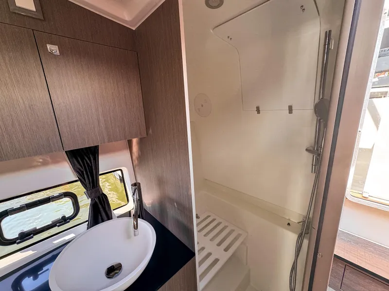 Slide: The Image of 2024 Beneteau Flyer 10 bathroom with sink, shower, and window. - 12