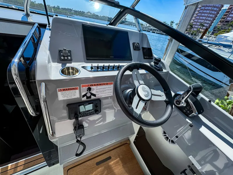 Slide: The Image of 2024 Beneteau Flyer 10 helm with modern controls and waterfront view. - 2