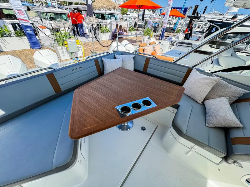 Slide: The Image of 2024 Beneteau Flyer 10 boat interior with cushioned seating and wooden table. - 7