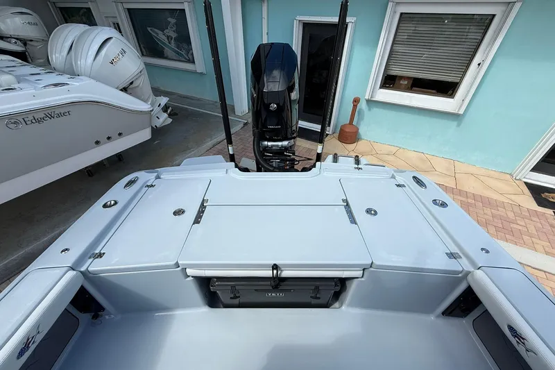 Slide: The Image of 2026 Crevalle 26 HCO boat deck with motor, docked beside EdgeWater vessel. - 17