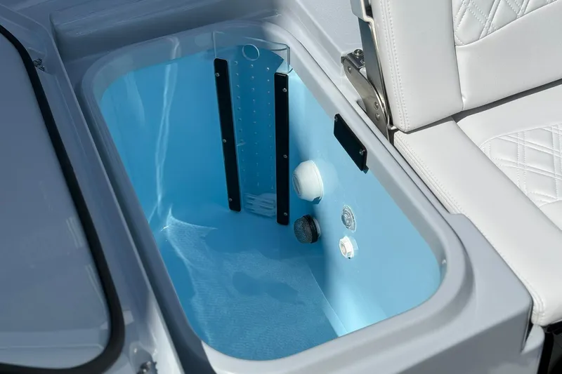 Slide: The Image of 2026 Crevalle 26 HCO boat interior compartment with white seating and blue storage area. - 20