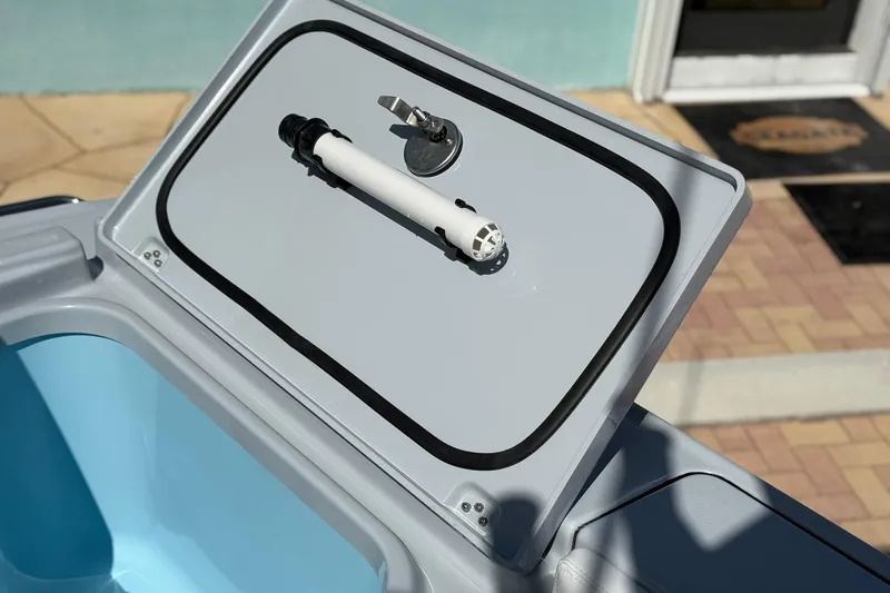 Slide: The Image of Crevalle 26 HCO 2026 boat compartment with open lid and latch mechanism. - 21